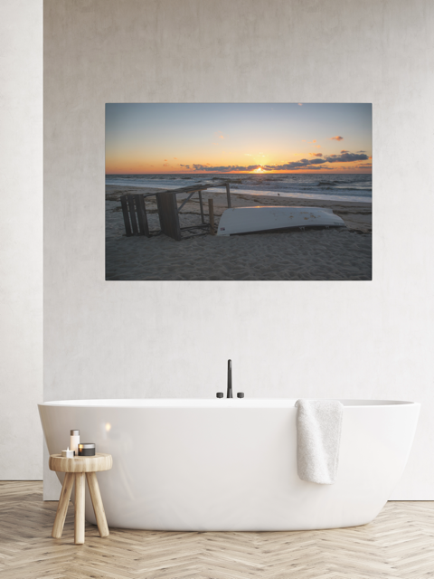 Canvas print of a Jersey Shore sunrise, placed above a white bathtub in a room.