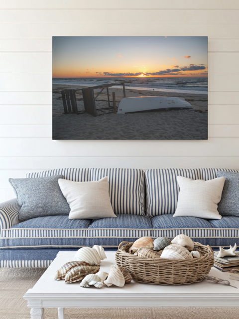 Canvas print of a Jersey Shore sunrise above a sofa with decorative items on a coffee table.