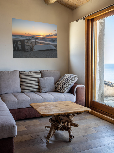 Living room with a gray sofa, wooden coffee table, and a canvas print of a Jersey Shore sunrise.