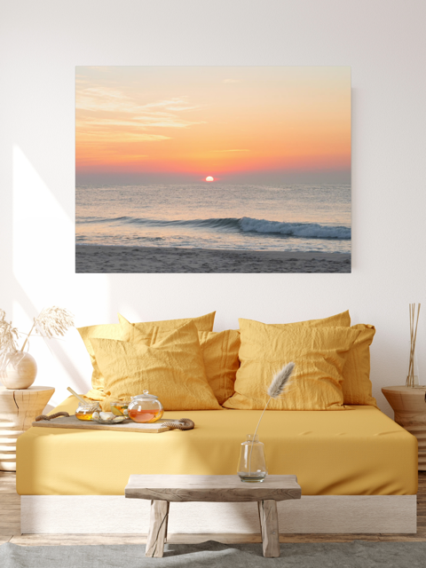 Living room with yellow sofa and a large canvas print featuring a summer sunrise over the Atlantic Ocean as seen from a quiet beach on the Jersey Shore.