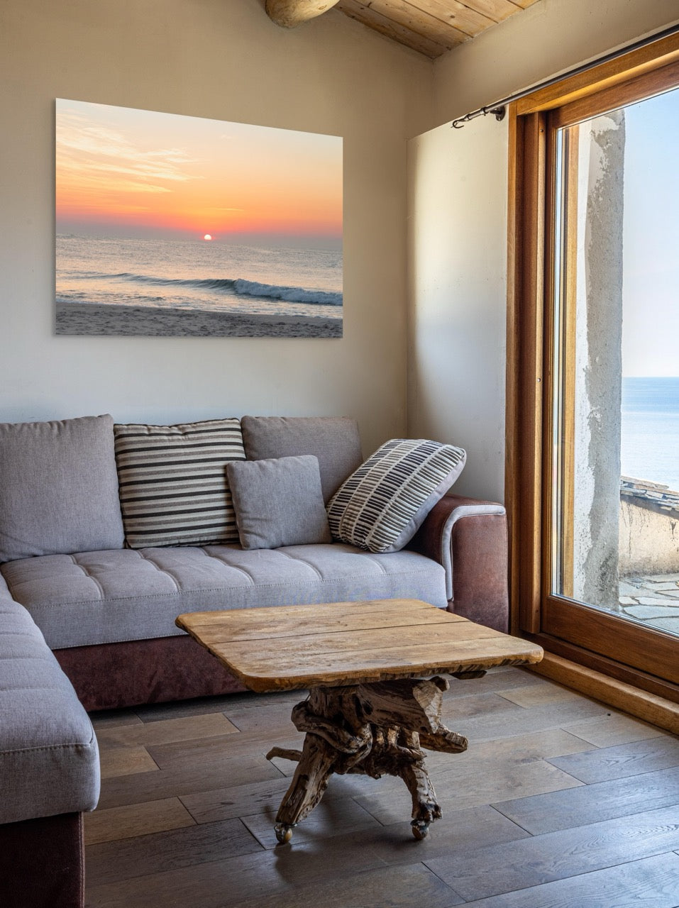 Living room with a gray sofa, wooden coffee table, and a large A canvas print featuring a summer sunrise over the Atlantic Ocean as seen from a quiet beach on the Jersey Shore on the wall.