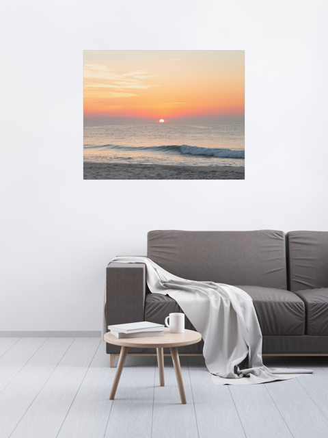 Living room with a gray sofa, small round table, and a large canvas print featuring a summer sunrise over the Atlantic Ocean as seen from a quiet beach on the Jersey Shore.