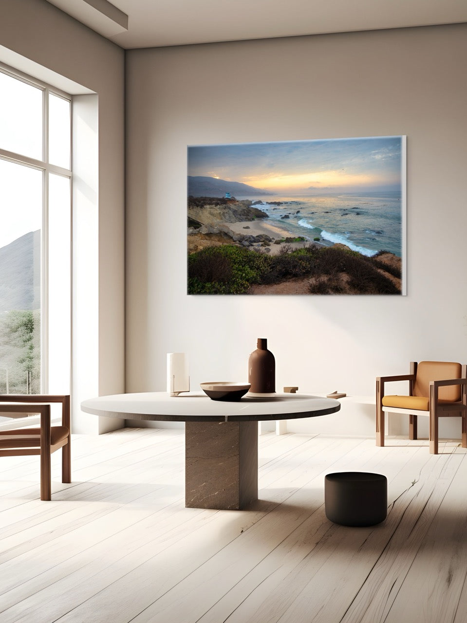 Modern living room with a large canvas print of the sunrise over the mountains as seen from the cliffs of Leo Carrillo State Beach near Malibu, California, wooden chairs, and a round table.
