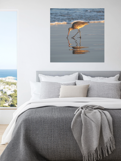 Bedroom with a canvas print of a long-billed curlew on the shoreline.
