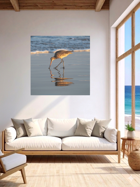 Living room with a sofa and a large window, featuring a canvas print of a long-billed curlew on the shoreline.