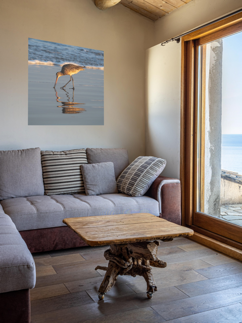 Living room with a gray sofa, wooden coffee table, and a canvas print of a long-billed curlew on the shoreline on the wall.