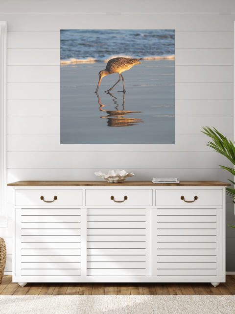 White cabinet with wooden top against a wall with a canvas print of a long-billed curlew on the shoreline