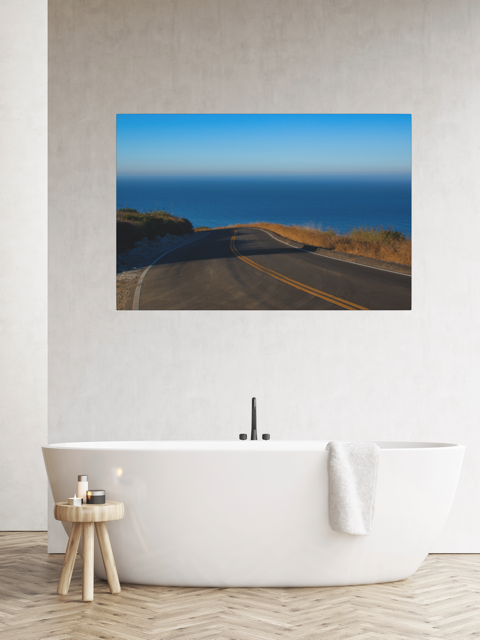 Bathroom with a canvas print of a winding mountain road above the Pacific Ocean in Malibu California