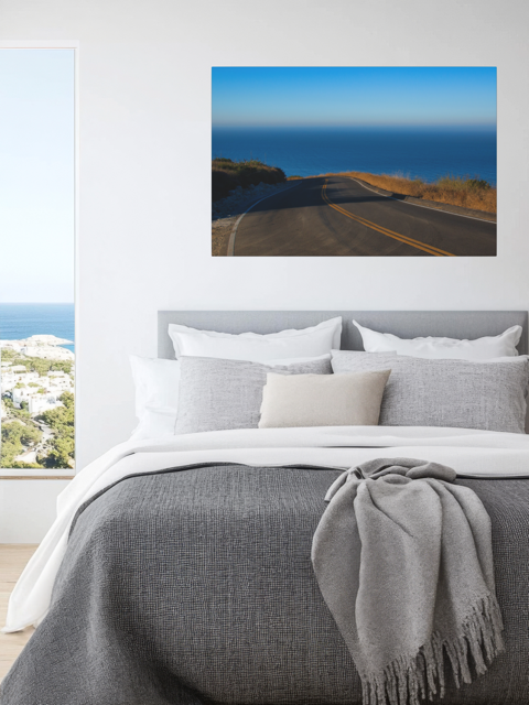 Bedroom with a canvas print of a winding mountain road above the Pacific Ocean in Malibu California.
