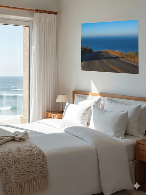 Bedroom with ocean view and canvas print of a winding mountain road above the Pacific Ocean in Malibu California on thewall