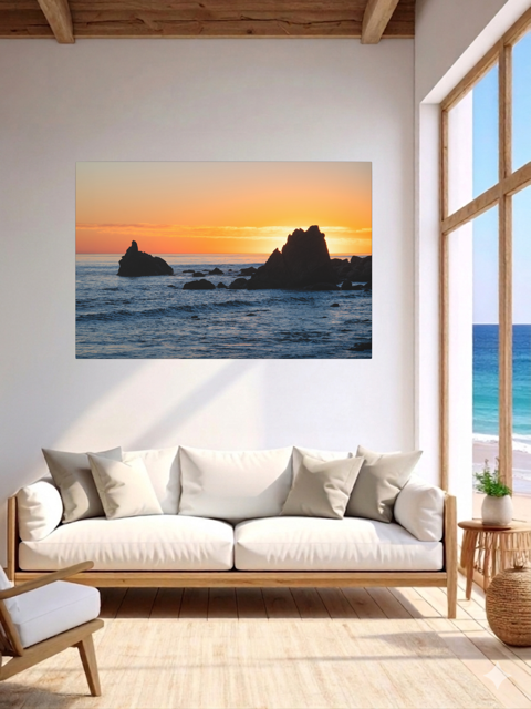 Living room with a canvas print of an ocean sunset with rocks.