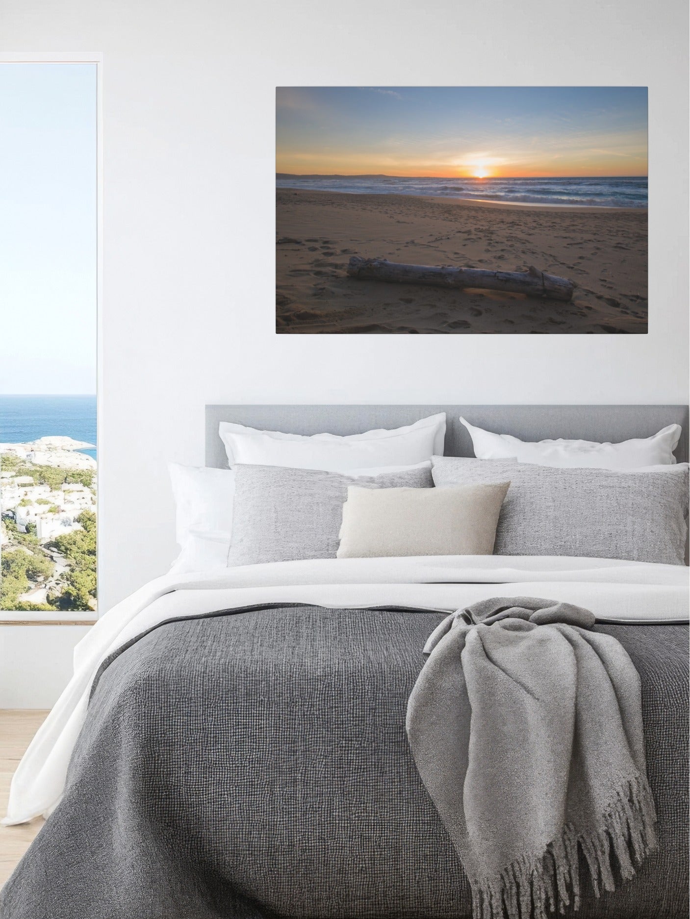 Bedroom with a canvas print of a Monterey California beach sunset with large driftwood log on sand on the wall