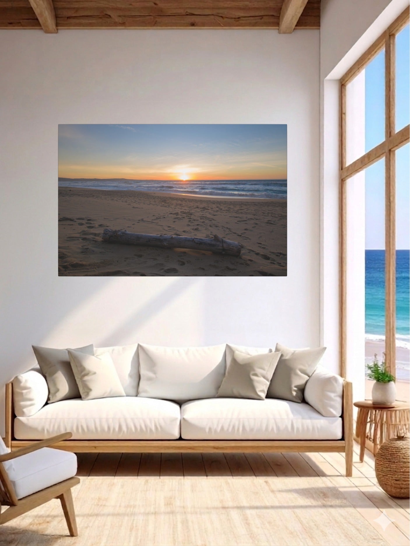 Living room with a canvas print of a Monterey California beach sunset with large driftwood log on sand on the wall