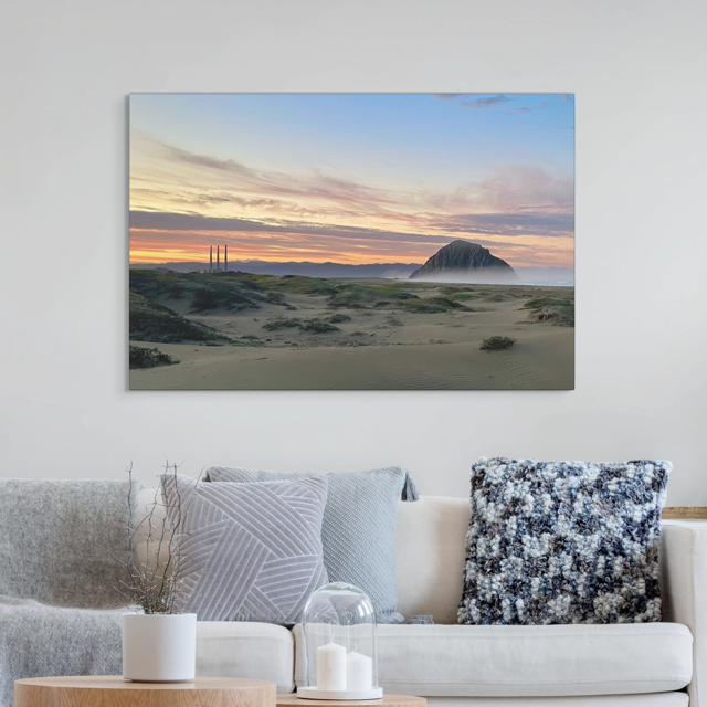 Sofa with decorative pillows and a vibrant sunrise over Morro Rock and Three Stacks from beach dunes canvas print