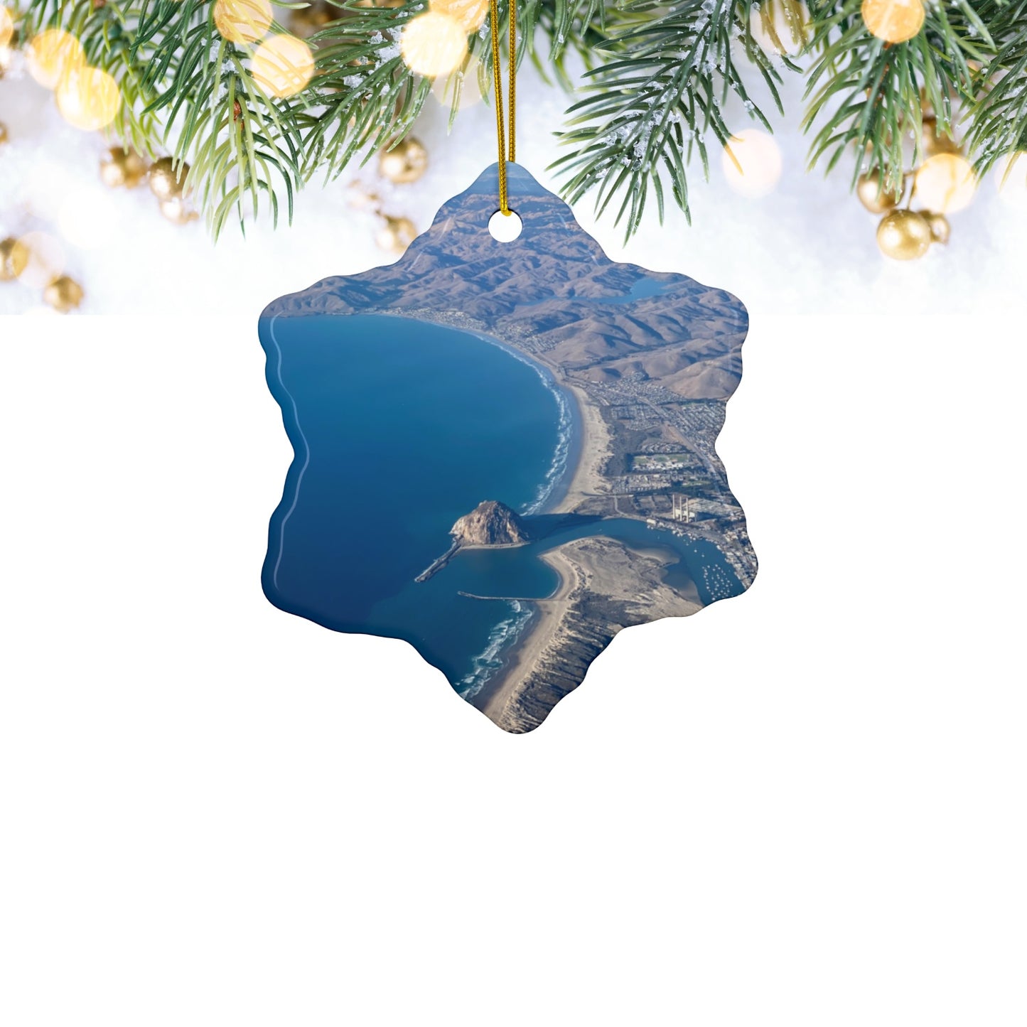 Ceramic holiday ornament featuring an aerial photograph of Morro Rock and the coastline of Morro Bay, California, with vibrant blue water and golden hills, hanging against a white background.