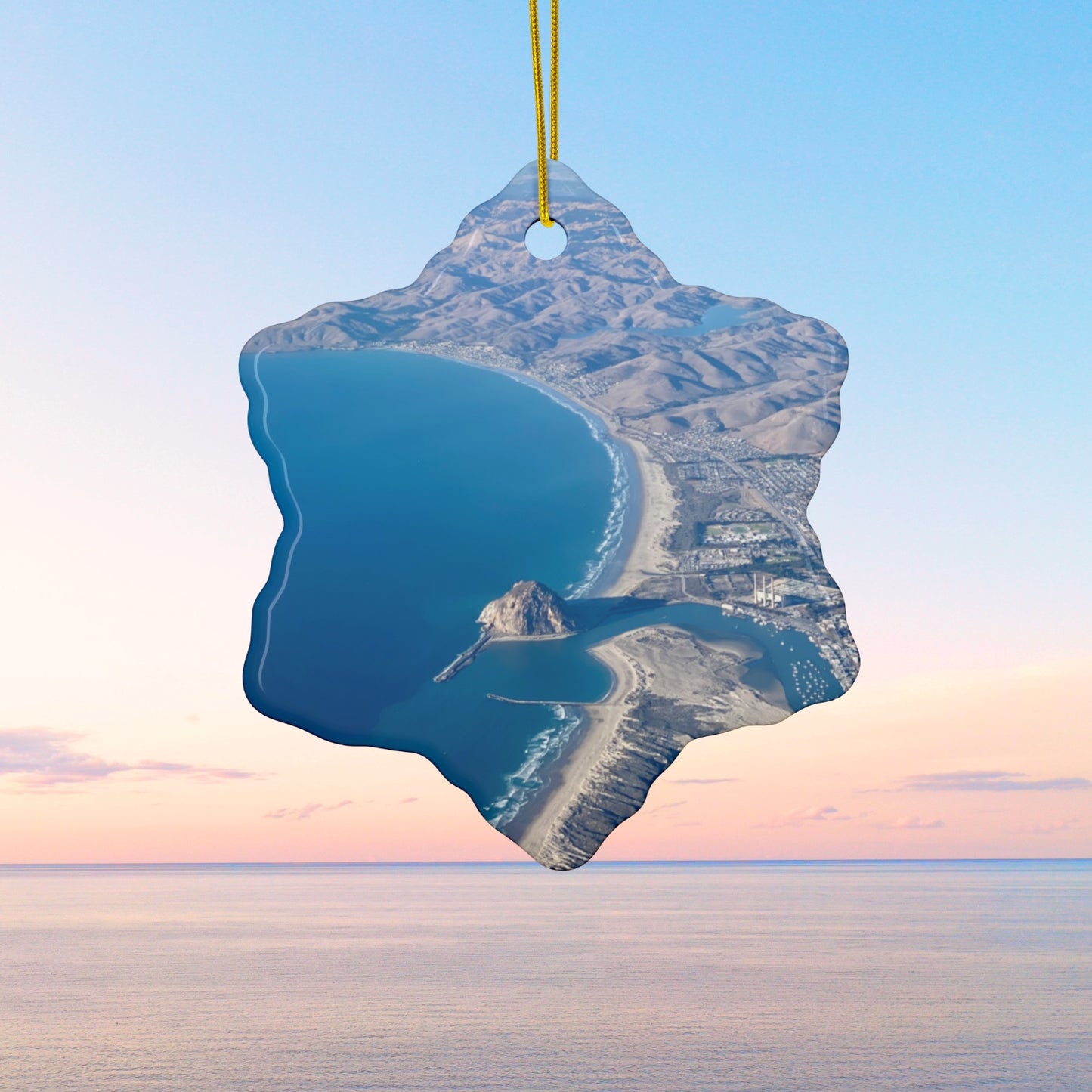 Ceramic holiday ornament featuring an aerial photograph of Morro Rock and the coastline of Morro Bay, California, with vibrant blue water and golden hills