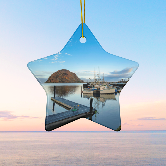 Star-shaped ceramic Christmas ornament featuring an early morning photograph of Morro Bay harbor with boats, a pier, and Morro Rock reflected in the calm water