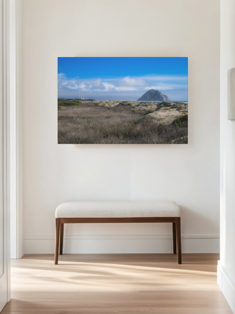 Morro Rock and stacks view from the beach dunes canvas print with a bench below in a room.