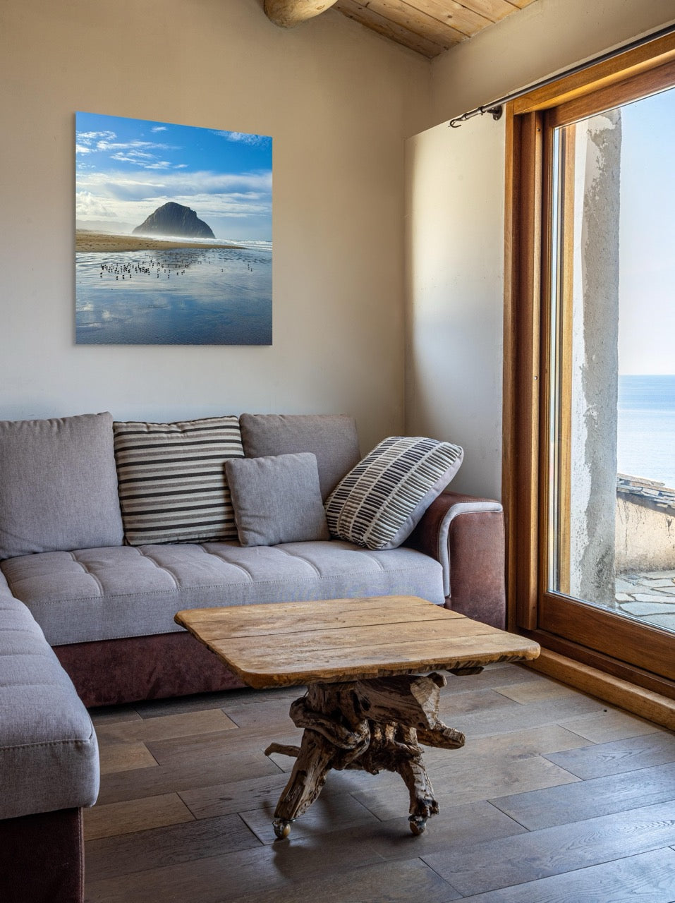 Living room with a gray sofa, wooden coffee table, and a large canvas print of Morro Rock on the wall.