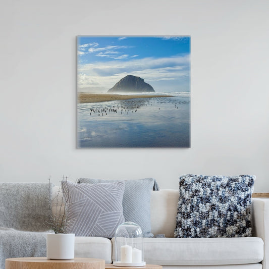 Canvas print of Morro Rock on a wall above a sofa with decorative pillows.