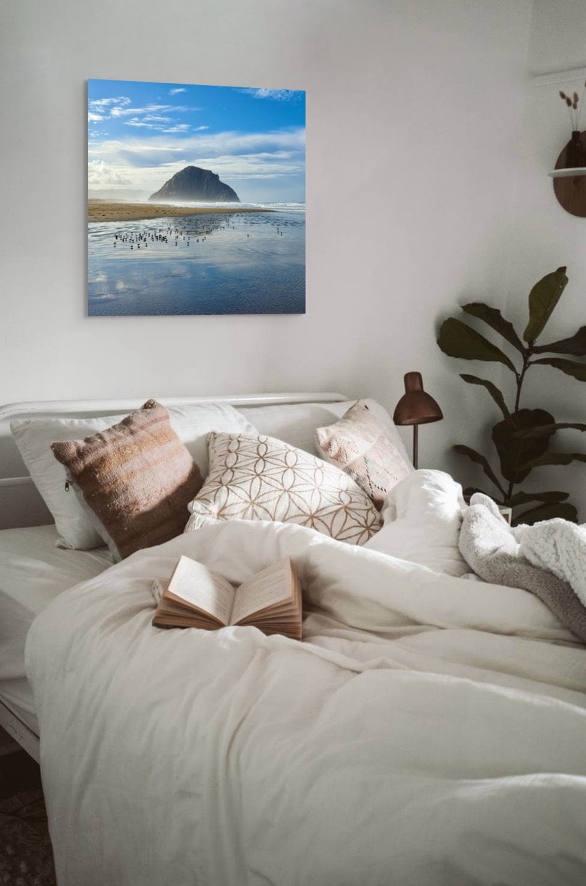 Bedroom with a large canvas print of Morro Rock above the bed.