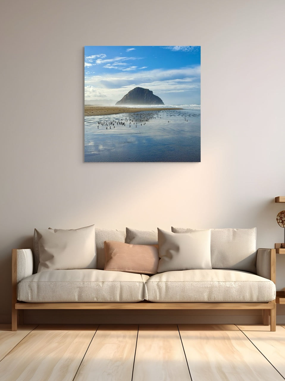 Sofa with decorative pillows in a room with a large wall-mounted canvas print of Morro Rock.