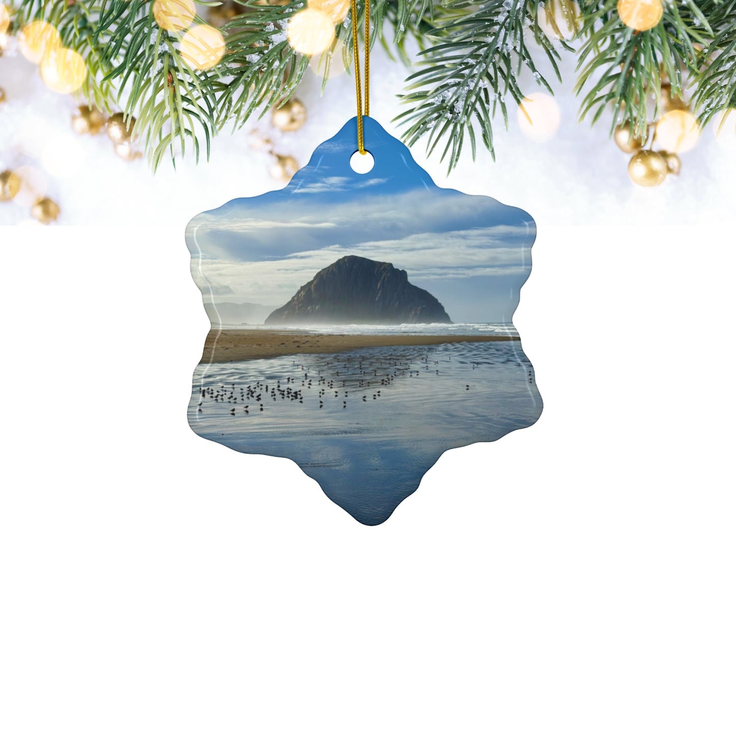 Ceramic holiday ornament featuring a professional photograph of Morro Rock in Morro Bay, California, with the Pacific surf in the foreground, hanging from a tree.
