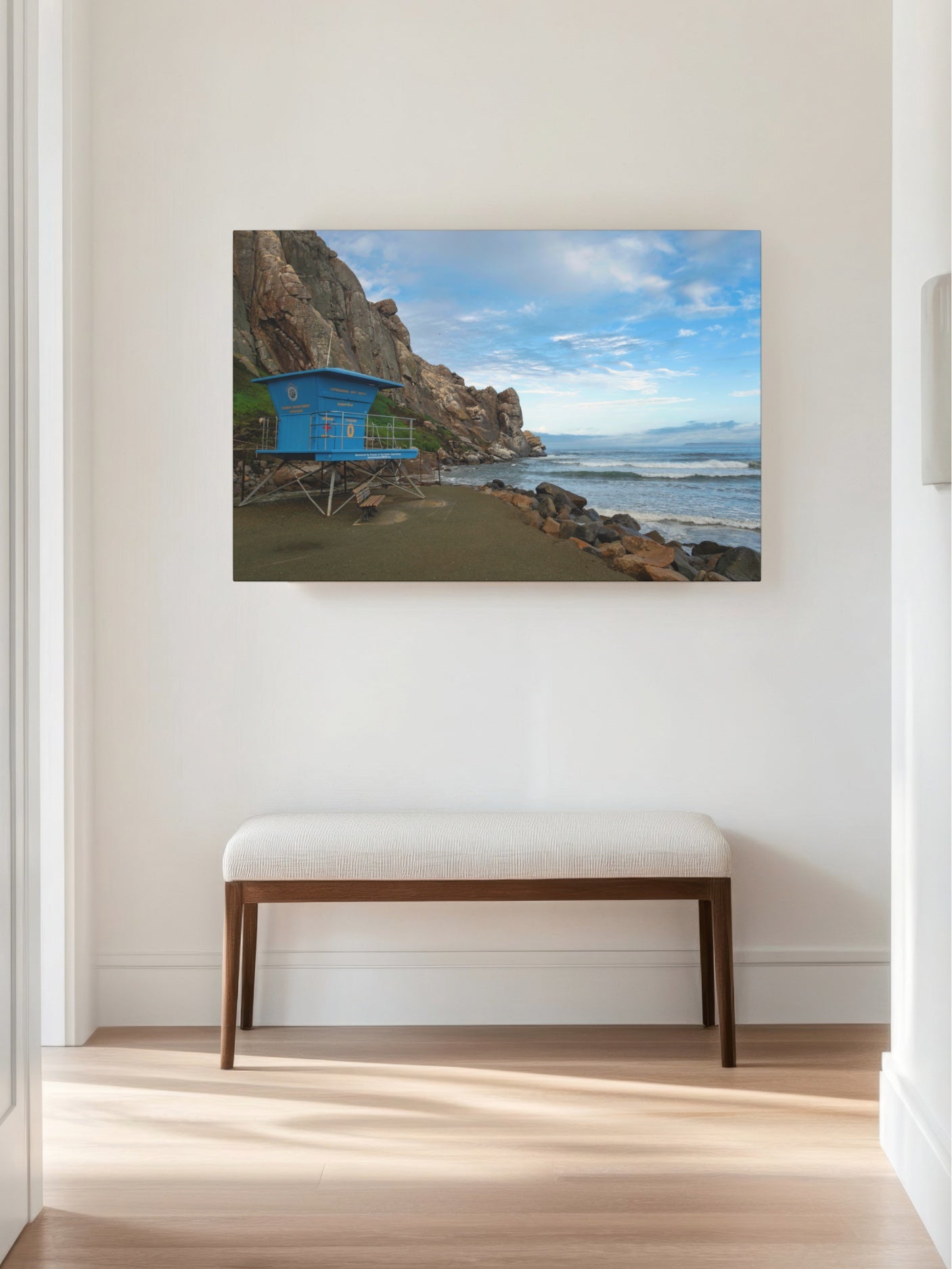 Blue lifeguard tower at the base of Morro Rock in Morro Bay California canvas print on a wall above a bench.