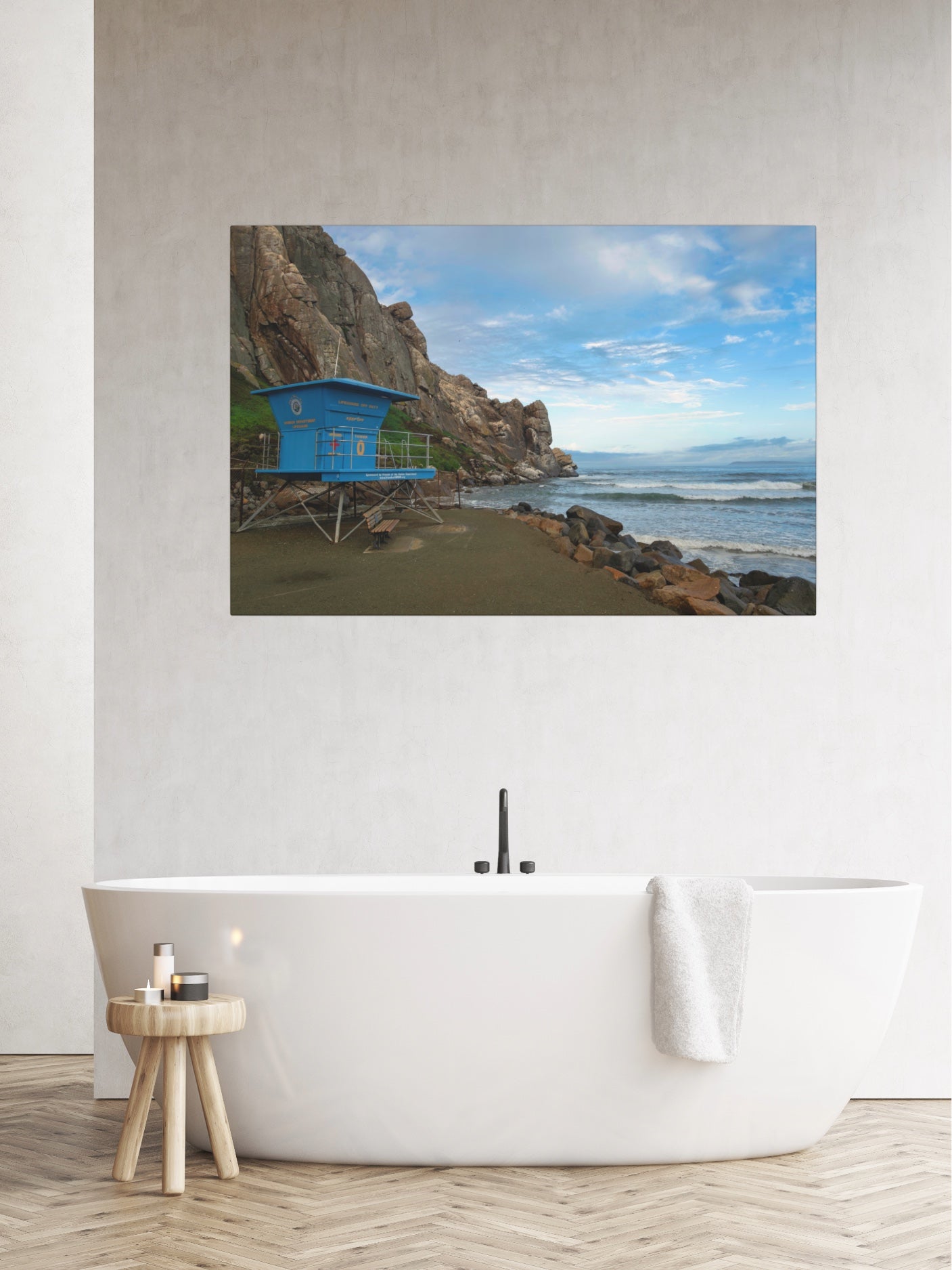 Blue lifeguard tower at the base of Morro Rock in Morro Bay California canvas print on a wall above a white bathtub.