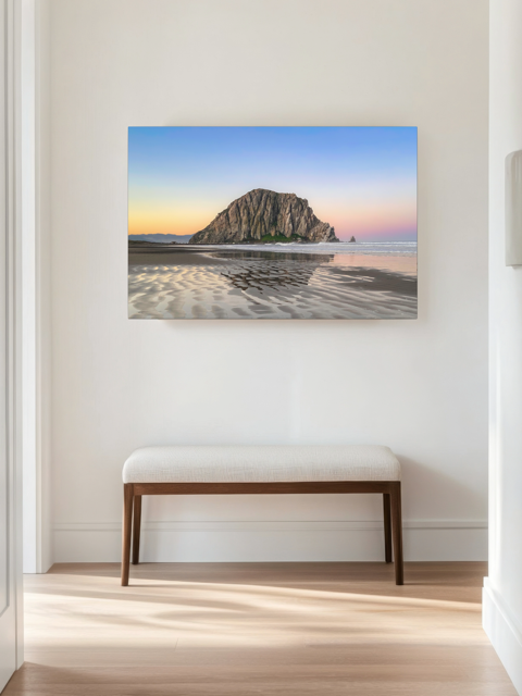 Canvas print featuring a Morro Rock morning reflection in wet beach sand on a wall in a room with a bench.
