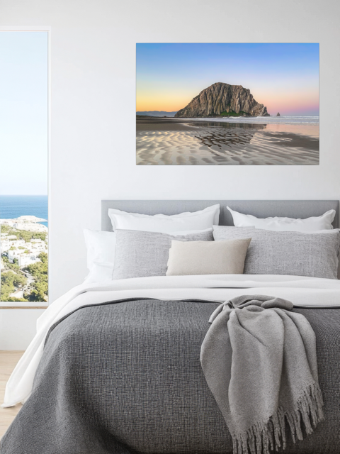 Bedroom with a canvas print featuring a Morro Rock morning reflection in wet beach sand.