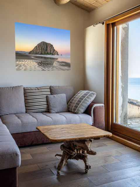 Living room with a canvas print featuring a Morro Rock morning reflection in wet beach sand.