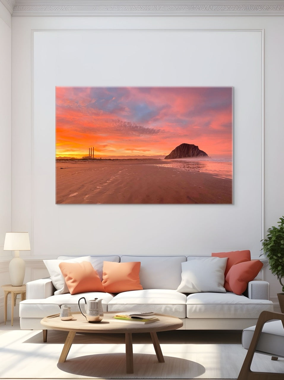 Living room with a large canvas print of Morro Rock and the stacks at sunrise on the wall above a white sofa.