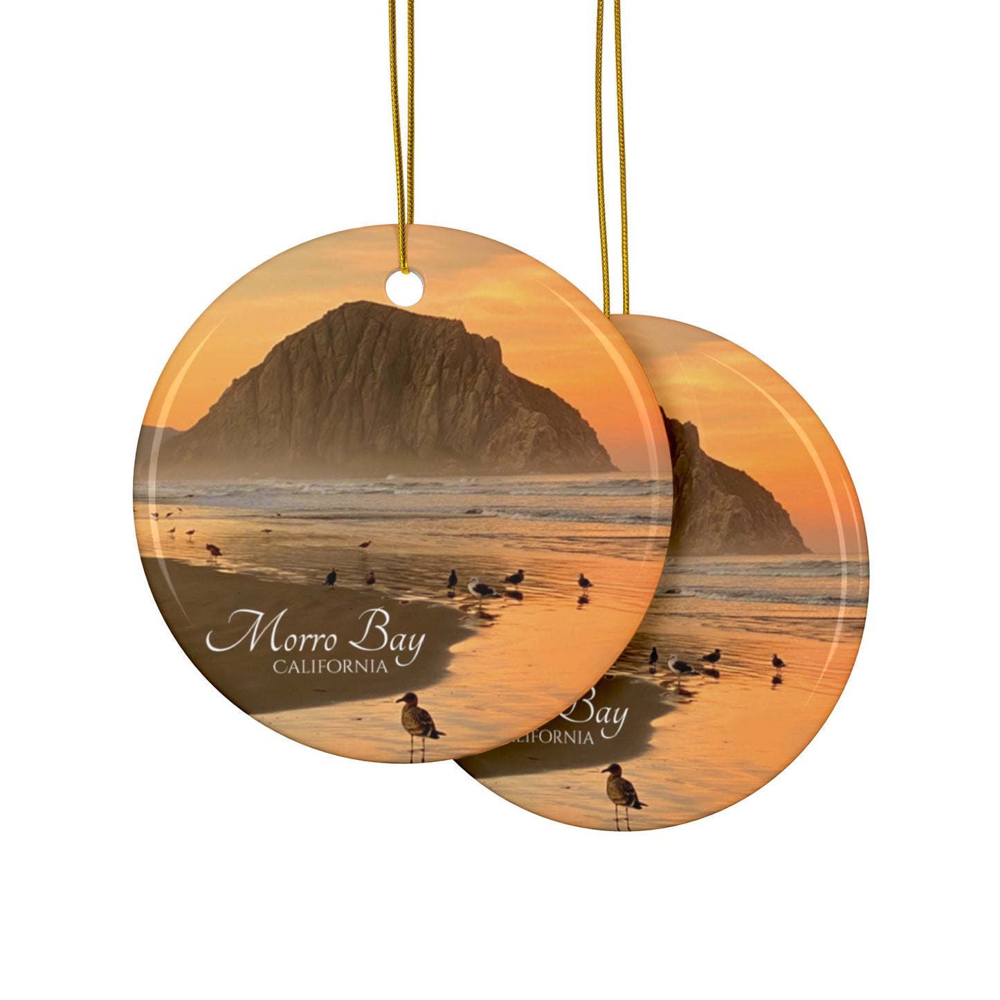 Front and back side of a ceramic Christmas ornament featuring a photograph of a golden sunrise over Morro Rock with shorebirds reflected in the wet sand of the shoreline.