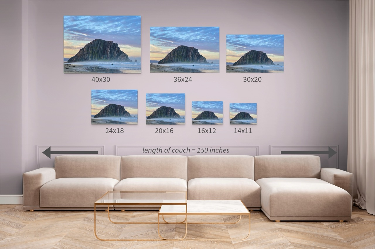 Wall art prints of a sunrise at Morro Rock in Morro Bay, California with a surfer on the beach with corresponding dimensions displayed above a beige sofa.