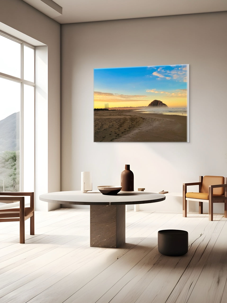 Modern living room with a round marble table and chairs, featuring a large canvas print of Morro Rock and the stack at sunrise.