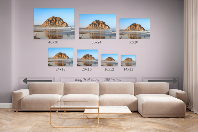 Wall art prints featuring Morro Rock reflecting in the wet sand with birds on the shoreline with corresponding dimensions displayed above a beige sofa.