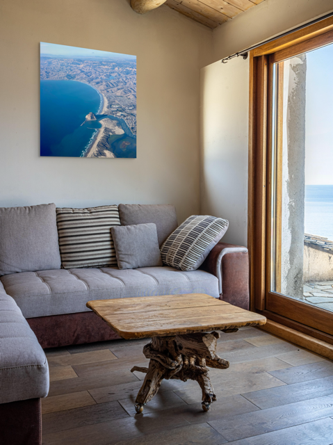 Living room with a gray sofa, wooden coffee table, and an aerial photo of Morro Rock and California coastline canvas print.