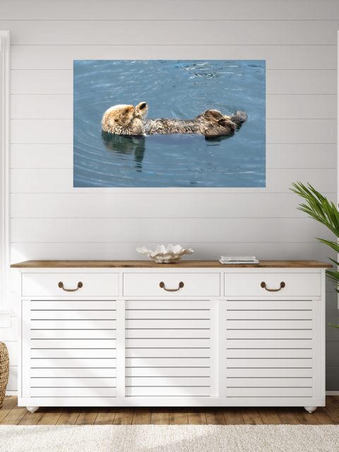White cabinet with wooden top against a wall with a nature-themed canvas print of a sea otter.