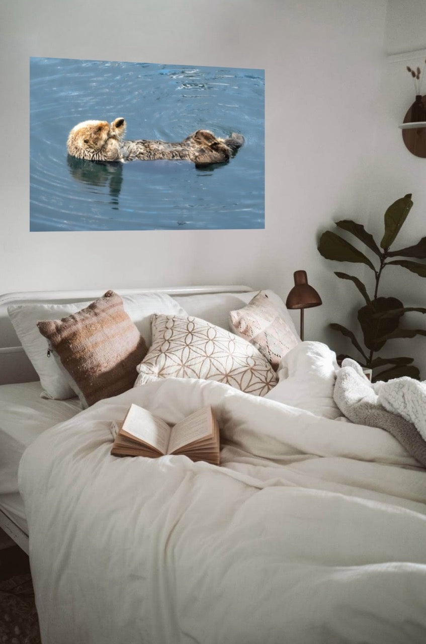 Room interior with a bed and wall art of a sea otter in water.