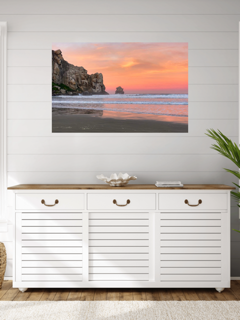 Beach scene artwork on a wall above a white cabinet with wooden top.