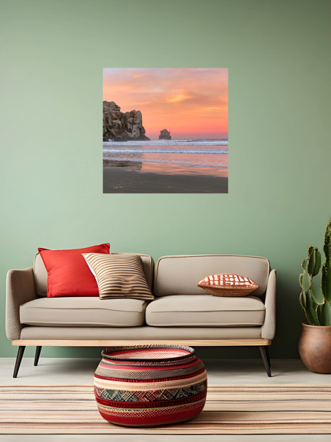 Living room with a beige sofa, colorful cushions, and a decorative vase on a wooden floor. A wall art piece of a beach sunrise is displayed on a green wall.