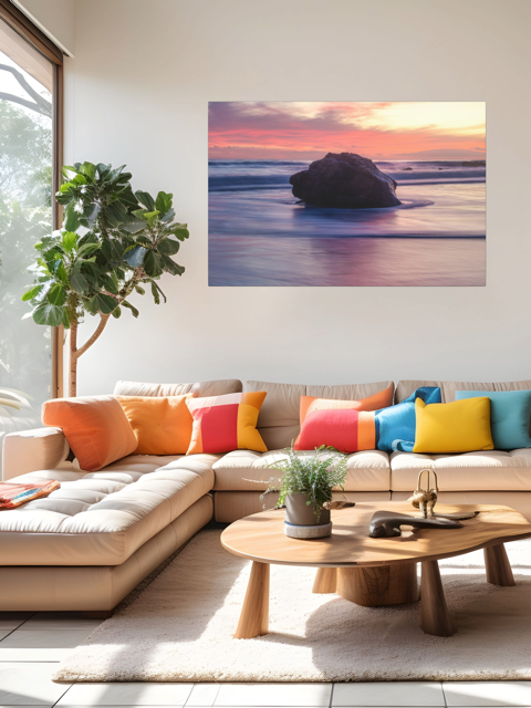 Modern living room with a sectional sofa, colorful cushions, and a canvas print of a large ocean rock on the wall.