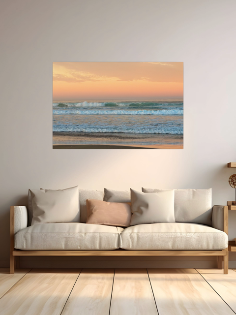Beige sofa with decorative pillows in a room with a large canvas print of a sunrise sky over ocean waves.