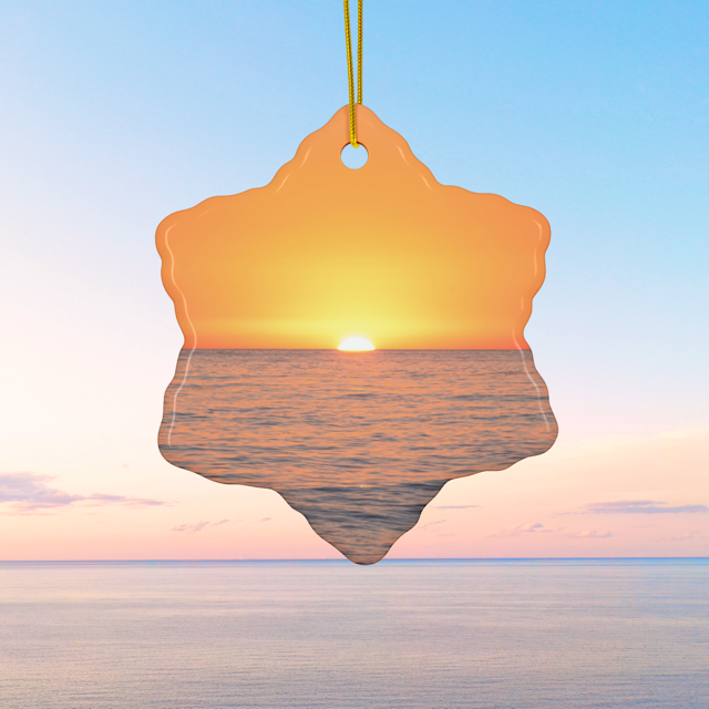 Ceramic Christmas ornament featuring a minimalist photograph of a vibrant orange and amber sunset sky over a calm Pacific Ocean.