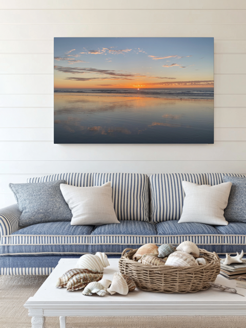 Living room with a couch, coffee table, and a Pacific Ocean sunset reflection on beach during King Tide canvas print.