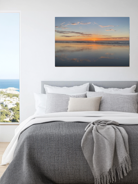 Bedroom with a Pacific Ocean sunset reflection on beach during King Tide canvas print on the wall.