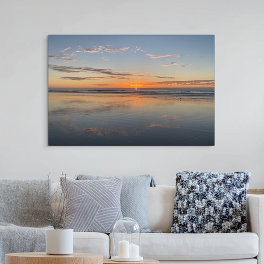 Pacific Ocean sunset reflection on beach during King Tide canvas print hanging above a living room sofa.