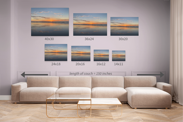 Wall art prints of sunset over water displayed above a sofa with measurements shown.