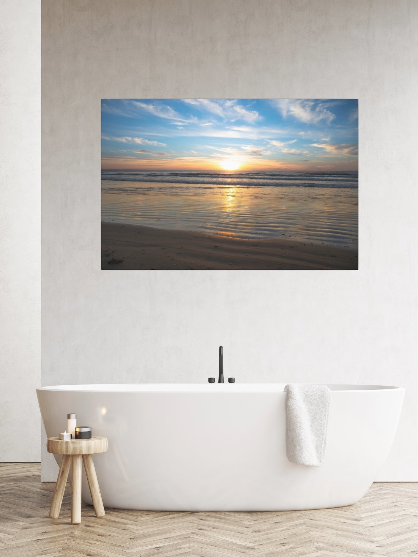 California beach sunset over the ocean with golden sand ripples canvas print on a wall above a bathtub in a bathroom.